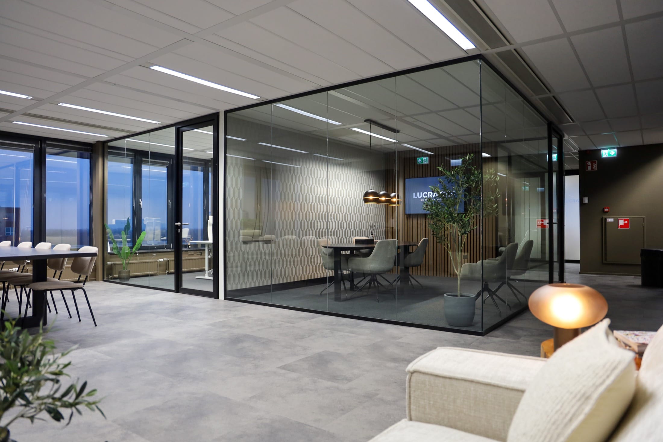 Kantoor van LUCRATIEF met glazen vergaderruimtes en lounge